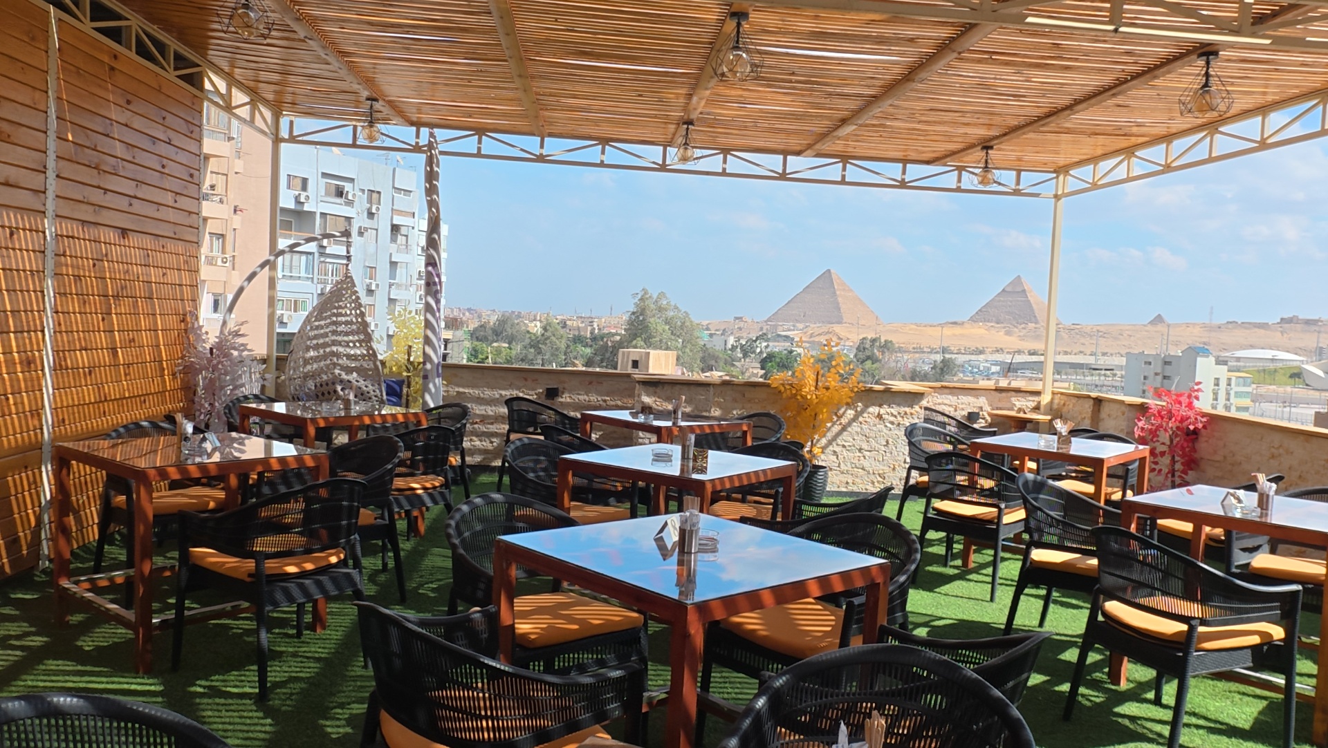 Sunny rooftop terrace at Grand View with a panoramic view of the Pyramids of Giza
